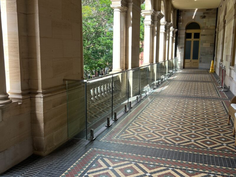 Long view down the colonnade showing the frameless glass balustrade set in front of the original balustrade.