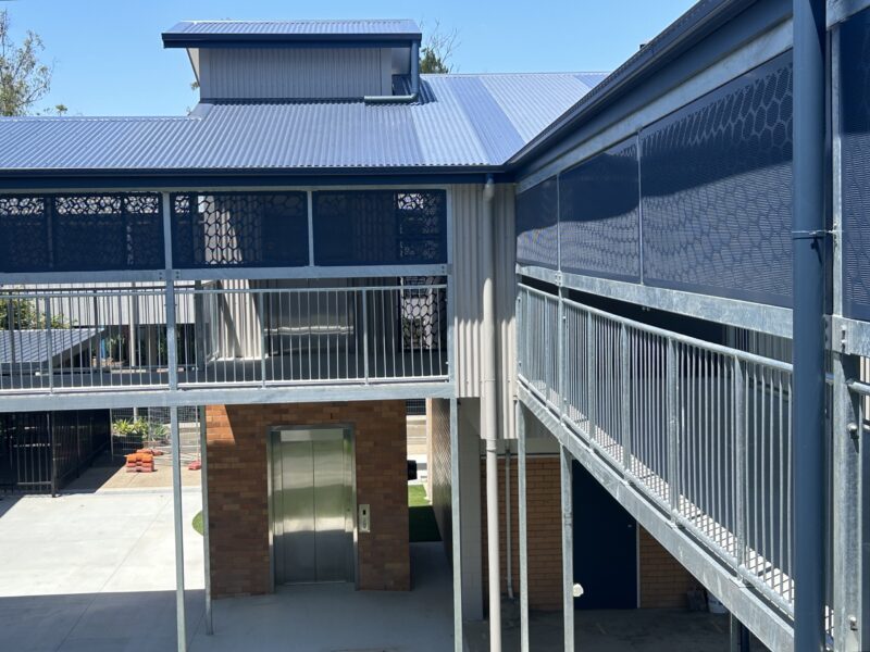 Brick lift tower linking new elevated walkways around the courtyard.
