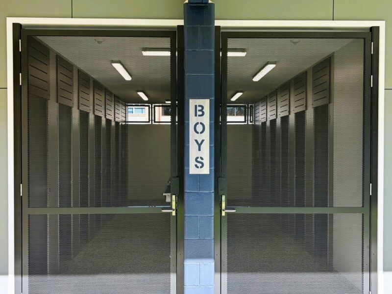 Boys amenities entry closed off by new full-height mesh security gates.